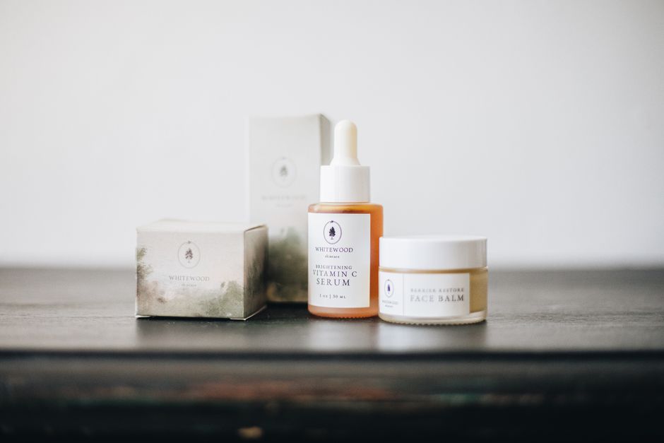 Elegant flat lay of natural skincare products, featuring a vitamin C serum and face balm.