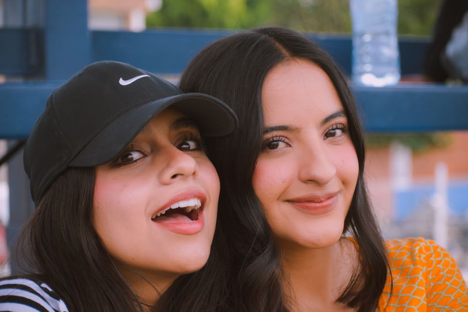 Close-up portrait of two young women enjoying their time outdoors, radiating happiness and friendship.