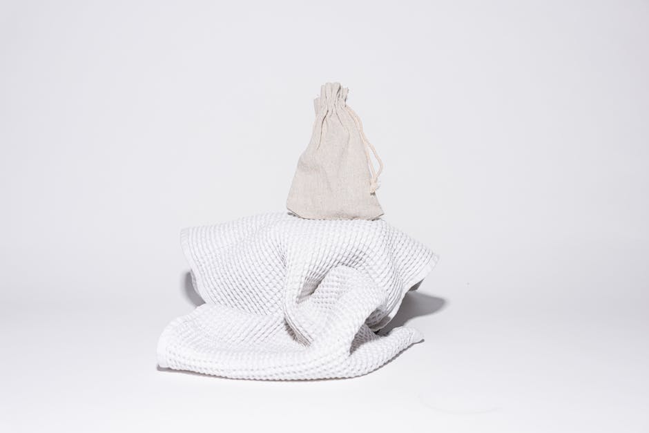Elegant minimalist display of a sack on a towel against a white background, perfect for bathroom product presentations.