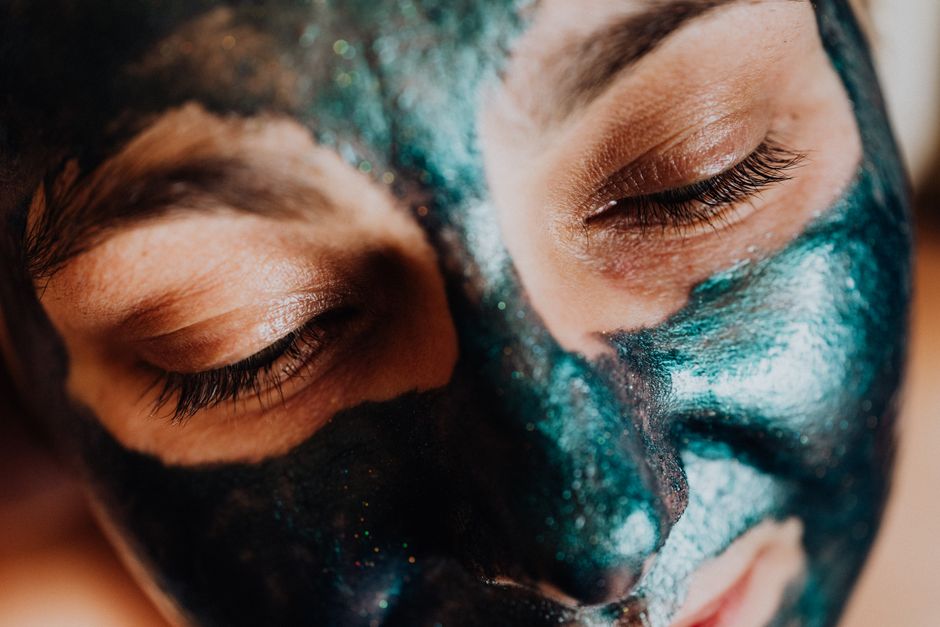 Serene close-up of closed eyes during a colorful facial mask treatment, highlighting relaxation and skincare.